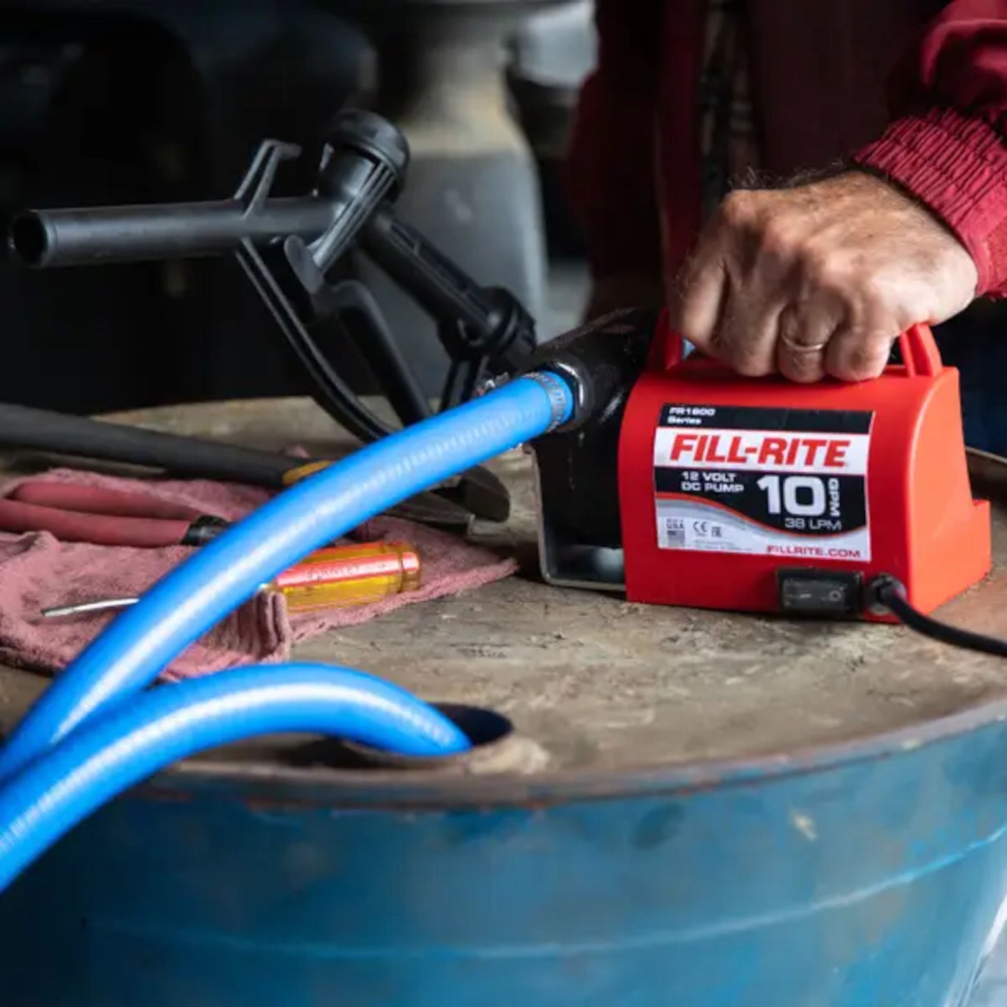 Fill-Rite FR1614 diesel fuel transfer pump connected to a drum with hose attached during active fuel transfer