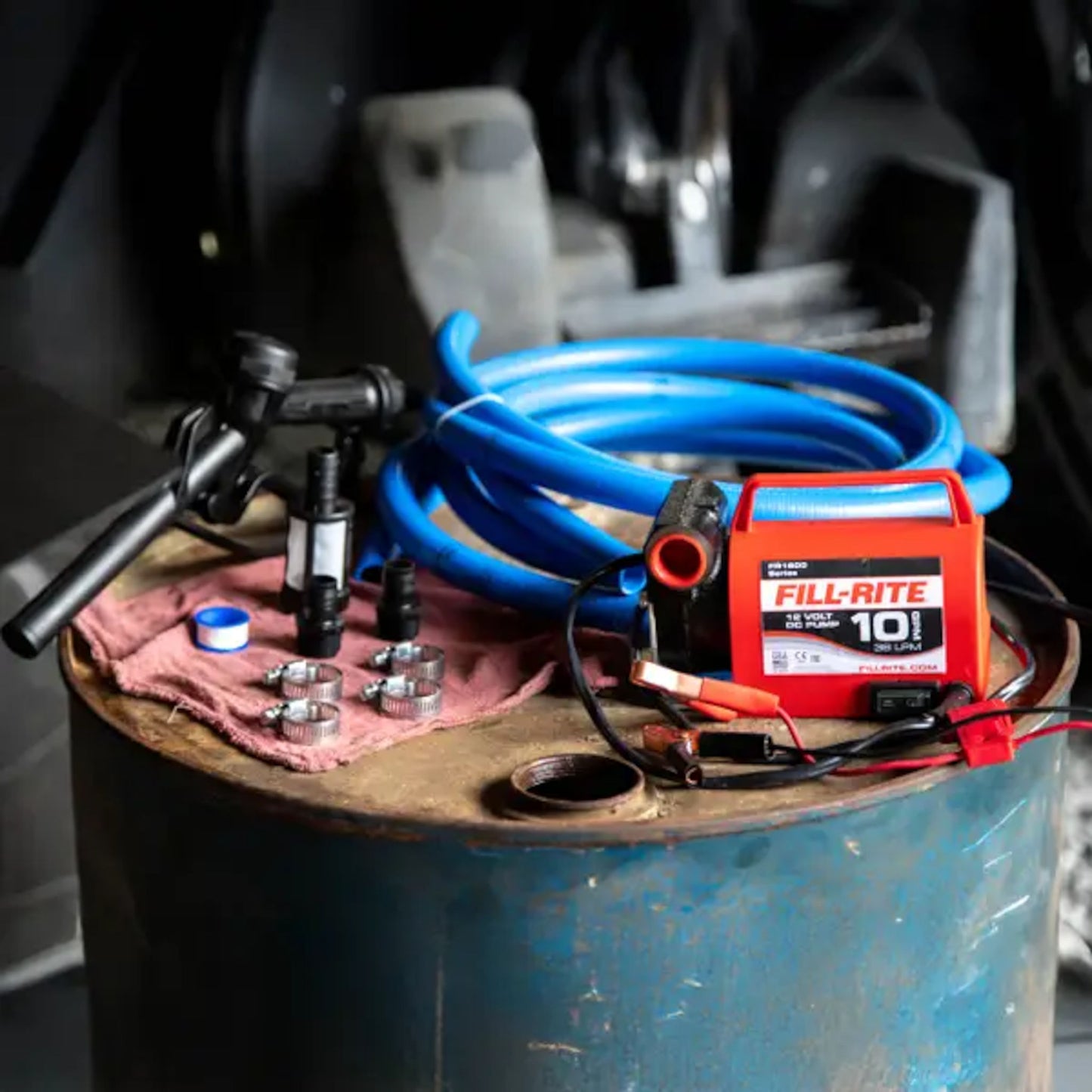 Fill-Rite portable diesel fuel transfer pump set up on a drum with hoses, nozzle, and fittings ready for use