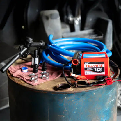 Fill-Rite portable diesel fuel transfer pump set up on a drum with hoses, nozzle, and fittings ready for use