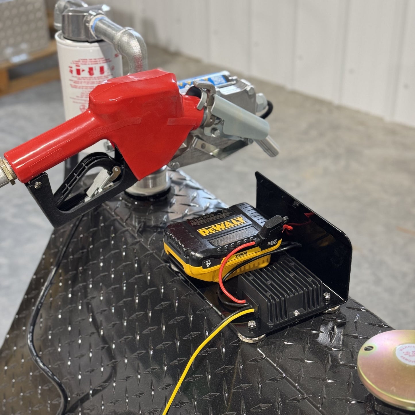 PowerMate Converter (SKU PMC1001) powered by DeWalt battery, connected to red fuel nozzle and pump