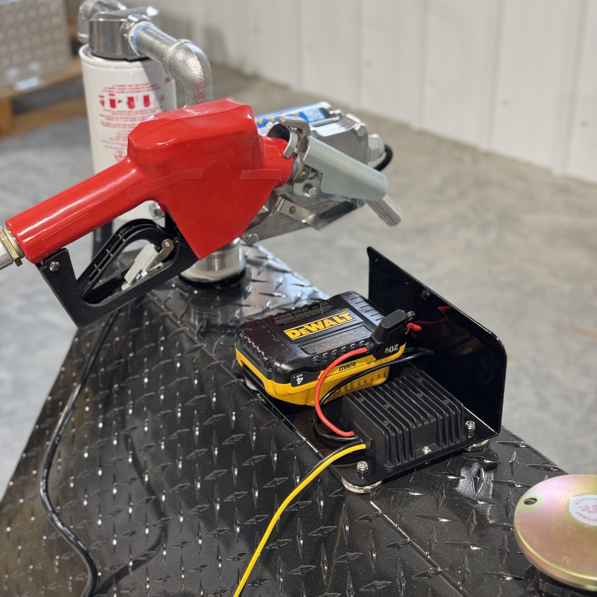PowerMate Converter (SKU PMC1001) powered by DeWalt battery, connected to red fuel nozzle and pump