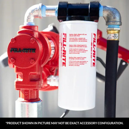 Close-up of Fill-Rite 1200KTF7018 10 micron fuel filter kit installed on red Fill-Rite transfer pump; designed for up to 25 GPM flow and 50 PSI max pressure; note: product shown may vary in exact accessory configuration