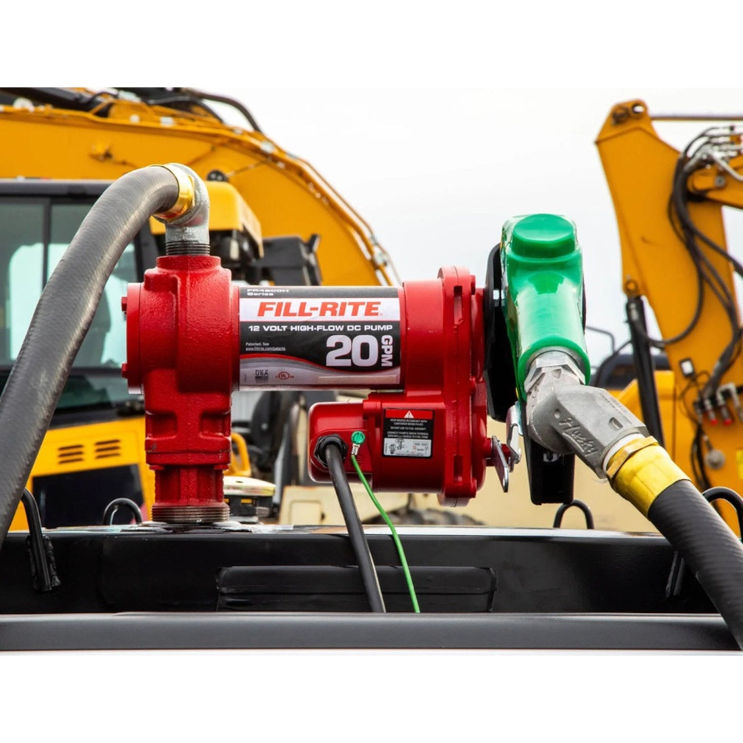 Fill-Rite FR4210HD 12V DC 20 GPM fuel transfer pump with green diesel nozzle in action fueling heavy equipment on job site