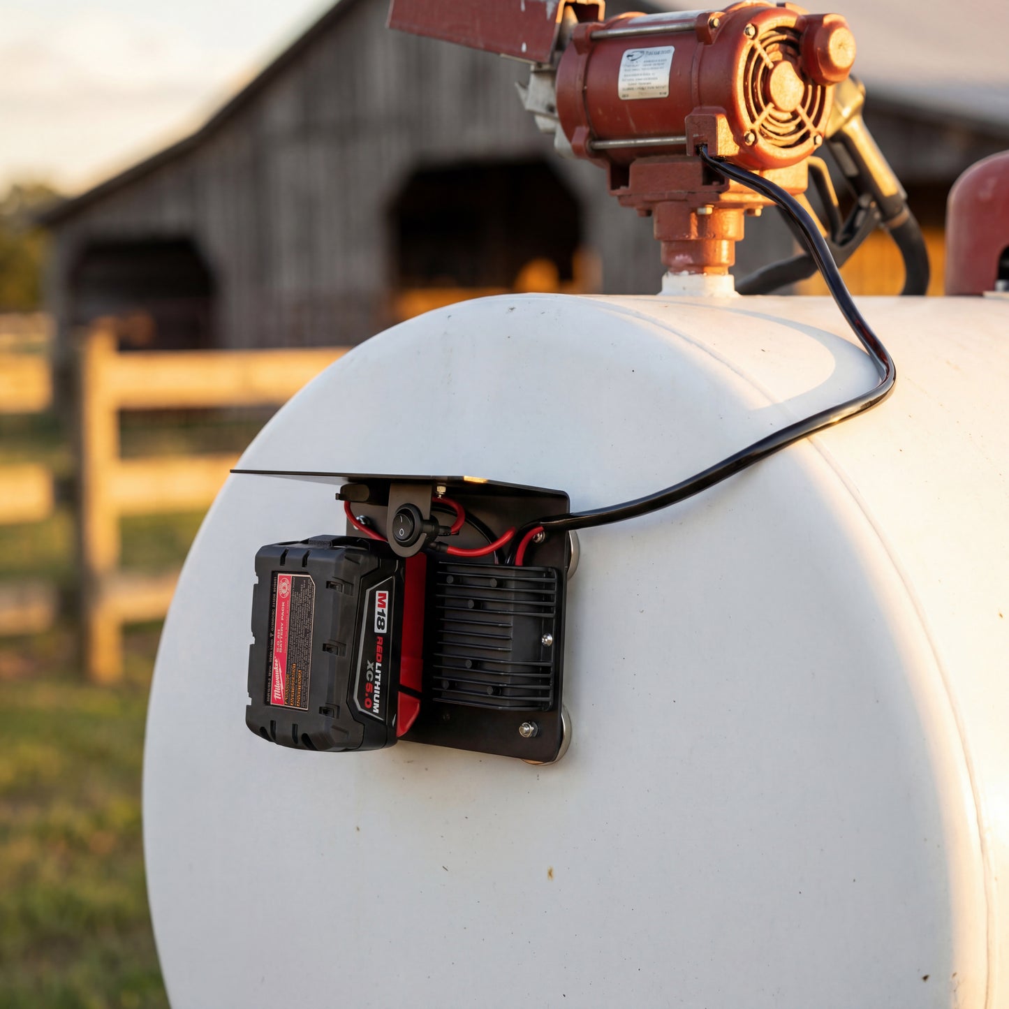 Milwaukee battery powering 12V fuel transfer pump using PowerMate converter mounted on fuel tank in outdoor setting