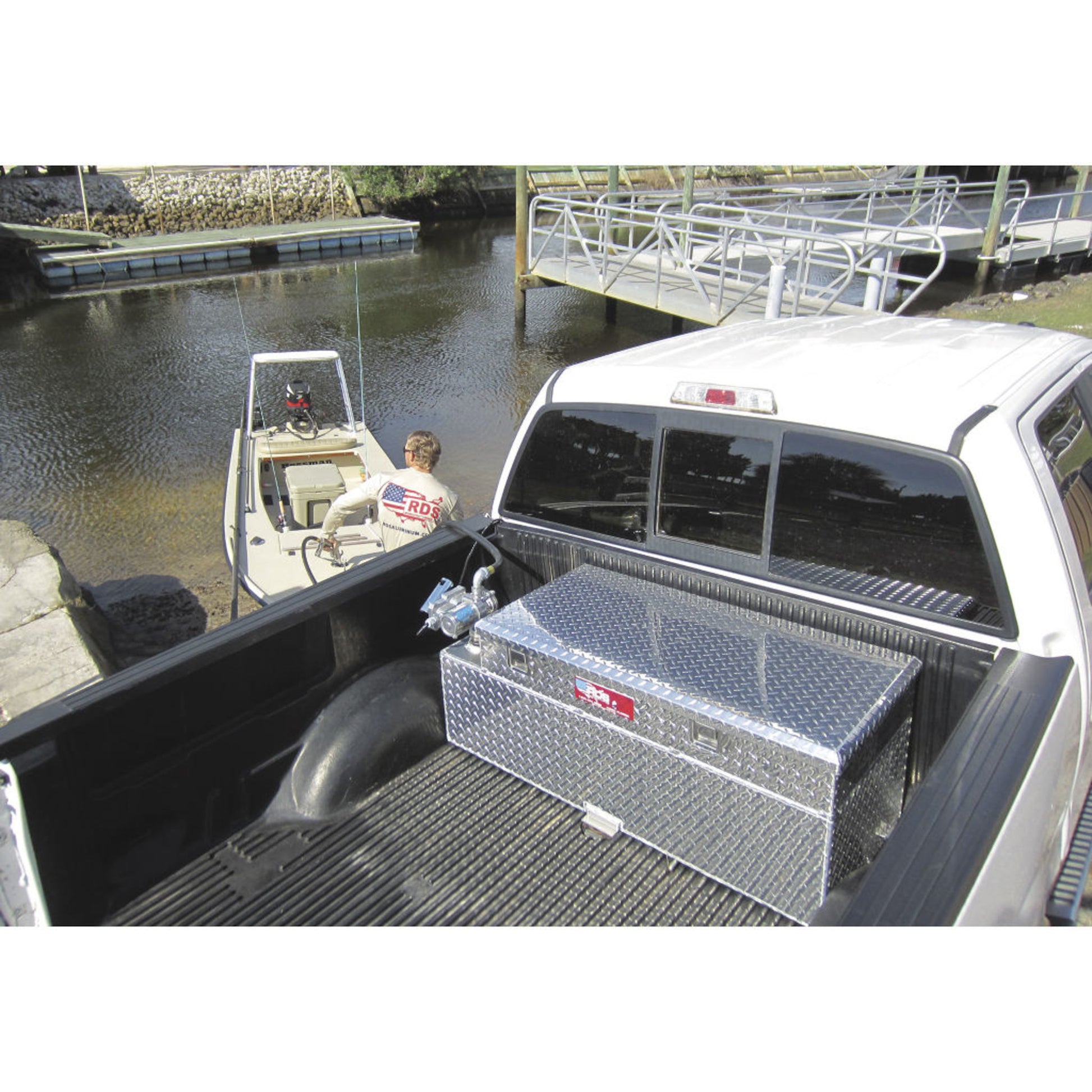 RDS aluminum transfer fuel tank/toolbox combo fueling boat from truck at dock: versatile marine transfer solution for waterfront use.
